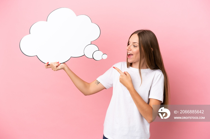 Young Lithuanian woman isolated on pink background holding a thinking speech bubble and pointing it