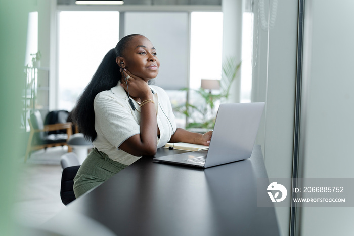 Businesswoman with laptop working in modern office