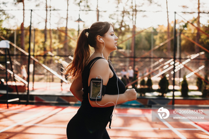 Side view portrait of a beautiful plus size women running in the morning in a sport park for losing weight.