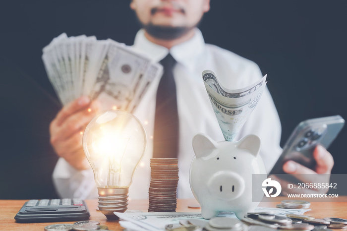 saving energy and money concept.Businessman hand putting money bank note dollar into piggy for saving money wealth and financial concept, Saving and financial accounts concept.