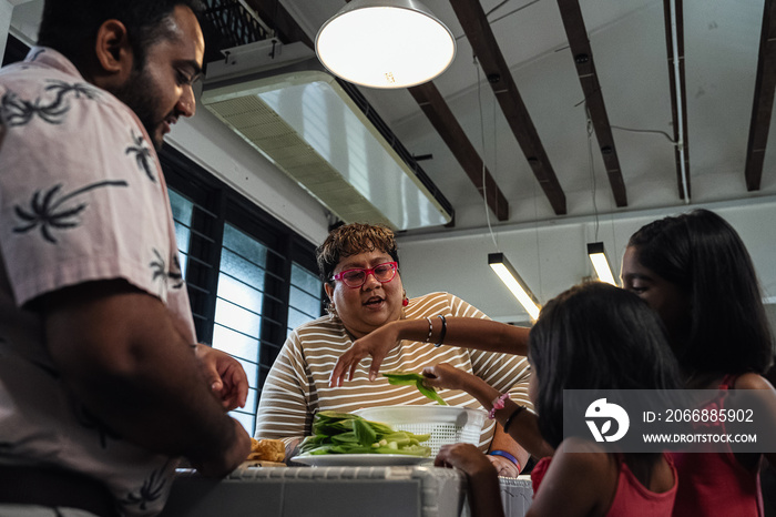 Kids helping their parent cook a healthy meal for the family dinner at home