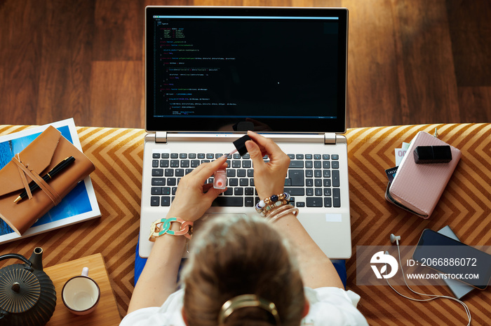 elegant woman developing software and polishing nails