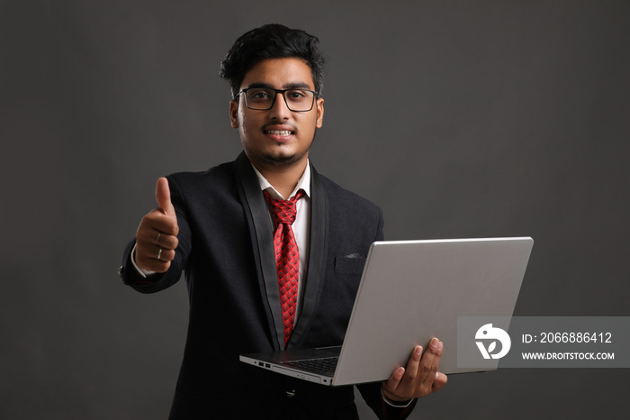 Young indian banker or officer using laptop