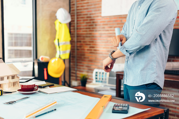 Enginner roll up the sleeves before working at workplace.