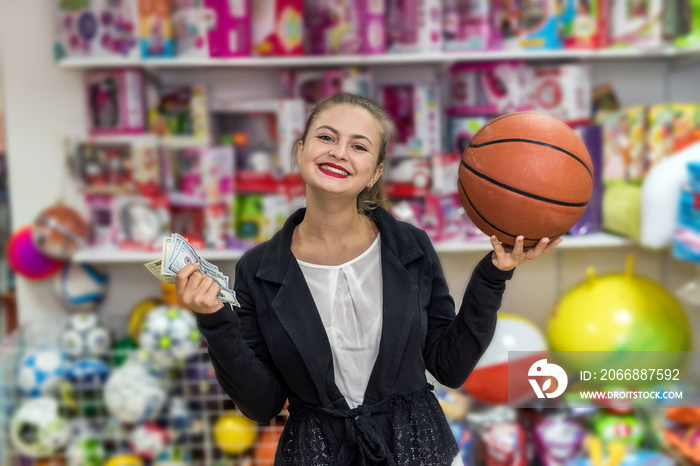 Woman with ball and dollars in toy shop