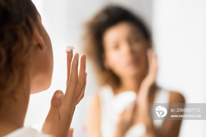 Unrecognizable Young Lady Applying Face Cream In Bathroom