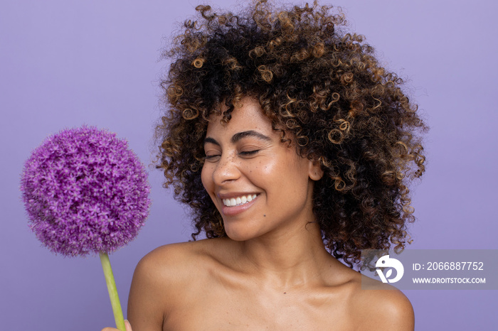 Smiling woman holding purple flower