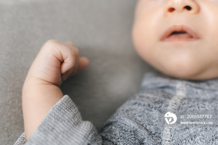 Cropped frame of newborn baby, nose, mouth and small hand in frame