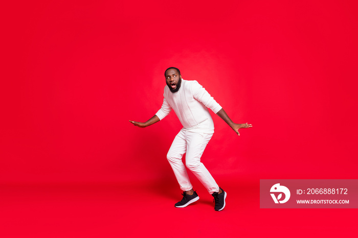 Full size photo of funny dark skin man prowl like bandit at night making newyear surprise for girlfriend going slowly tiptoe wear knitted sweater trousers isolated red background