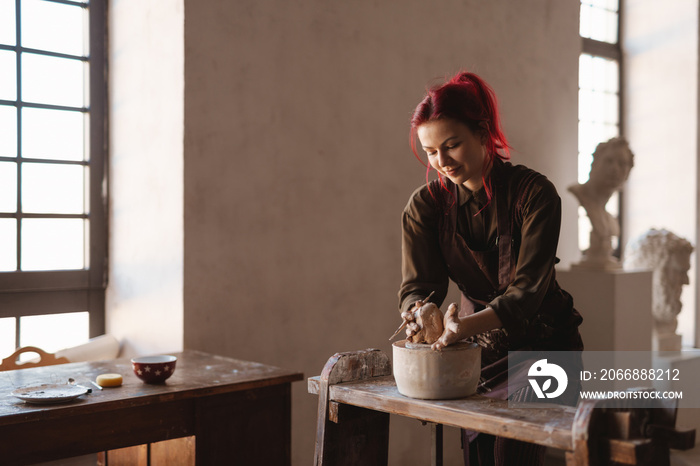 Young woman sculptor artist creating a bust sculpture