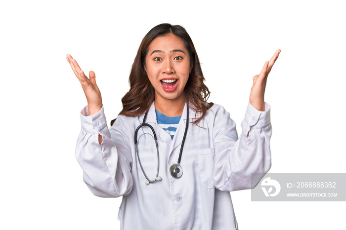 A young asian doctor woman receiving a pleasant surprise, excited and raising hands.