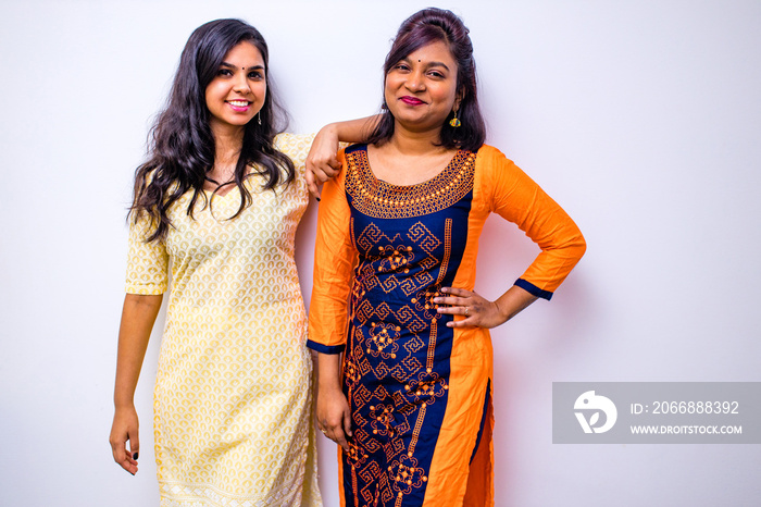 casual indian clothes ,two Indian woman in kurta posing over white wall