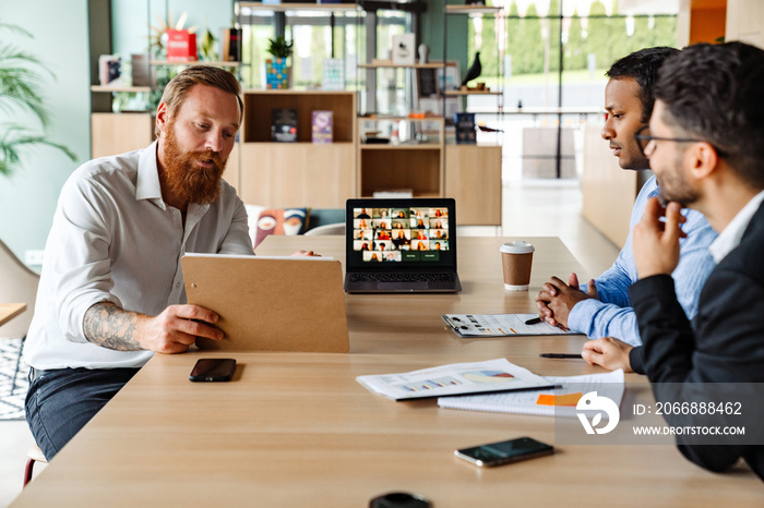 Group of multiethnic businesspeople talking with team during video conference in office