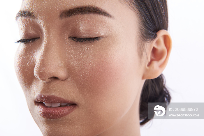 Close up of wet face of young Asian woman