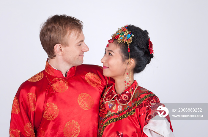 Mixed Race Bride and Groom in Studio wearing traditional Chinese wedding outfits