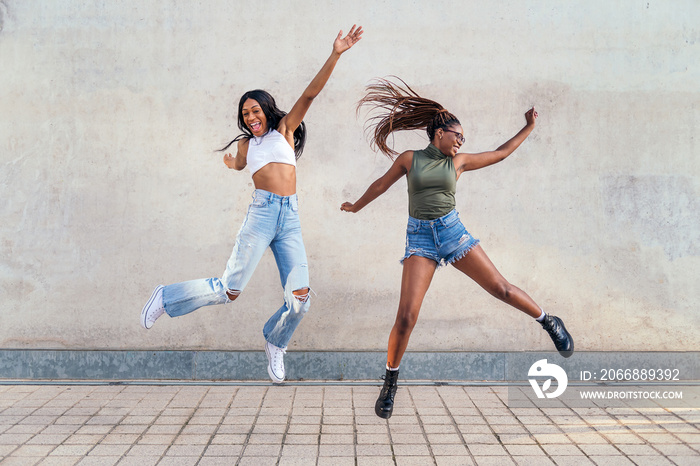 two young black girls jumping happy