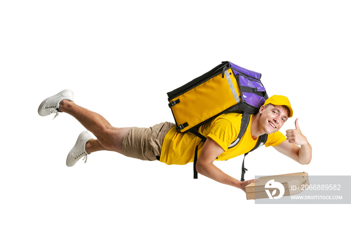 Young delivery man in yellow uniform flying to deliver order isolated on white background. Concept of convenience, speed, comfort, safety, service.