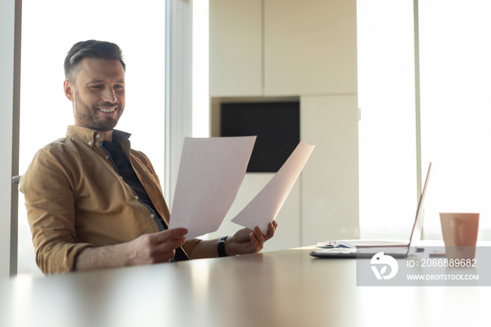 Joyful Businessman Reading Papers Having Success At Work In Office