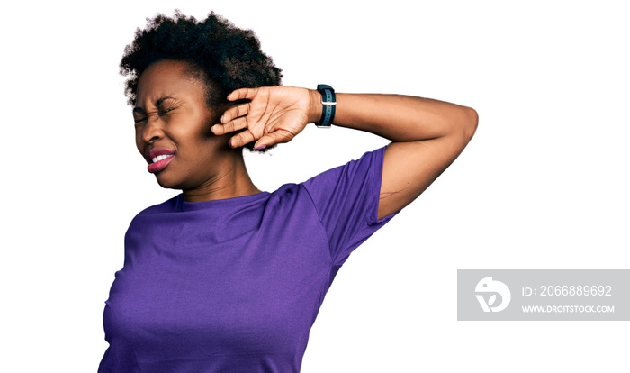 African american woman with afro hair wearing casual purple t shirt stretching back, tired and relaxed, sleepy and yawning for early morning