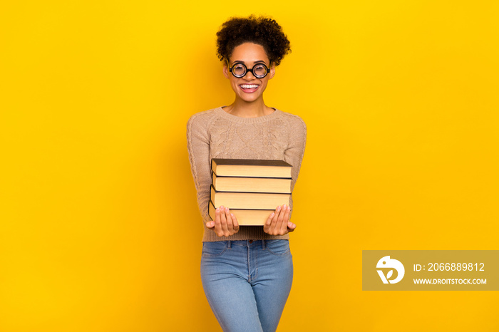 Photo of cute young brunette lady hold books wear eyewear sweater isolated on yellow color background