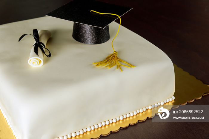 Cake with white fondant and decorations for graduation