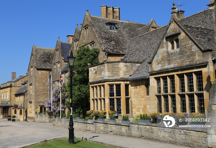 Old Cotswold stone buildings lining the main street in the picturesque village of Broadway, Gloucestershire, England.