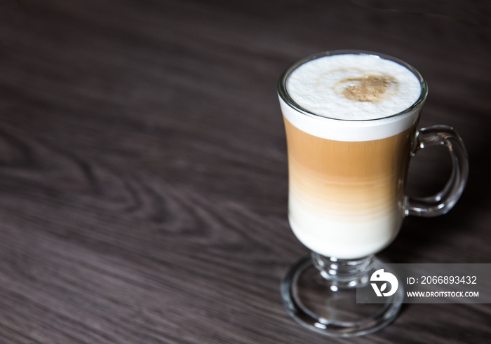 A hot and creamy Macchiato Coffee in a tall glass on a clean background