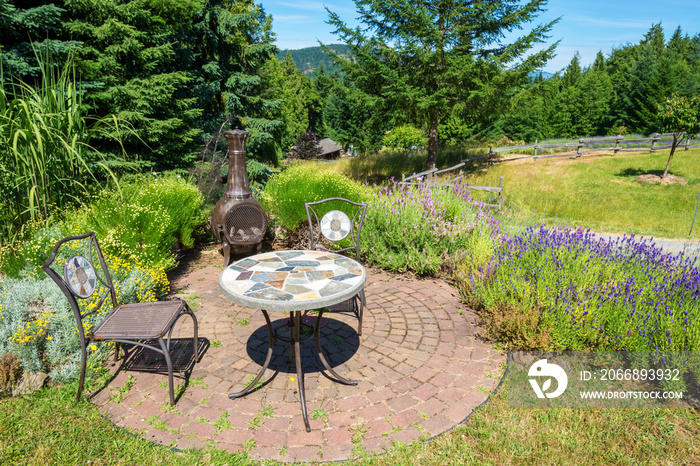 Rustic patio table in a lush garden with lavender plants.