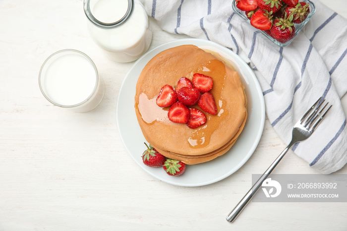 Composition with delicious pancakes, honey and strawberries on wooden table