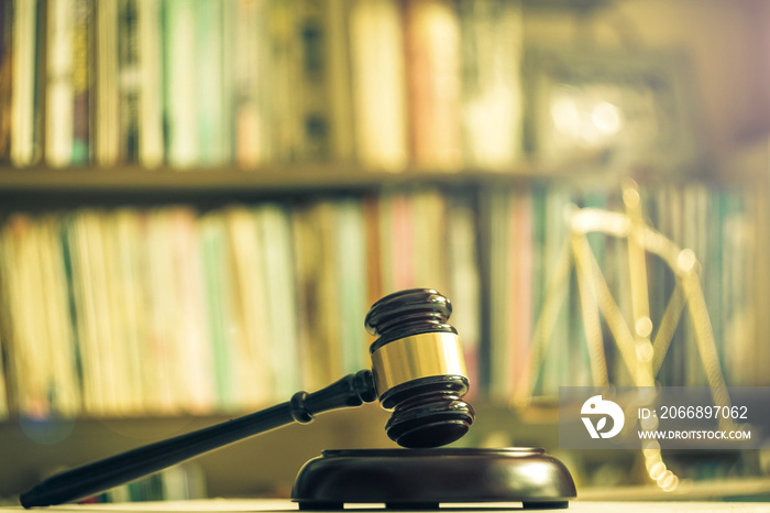 Wooden judge gavel with scales on library background