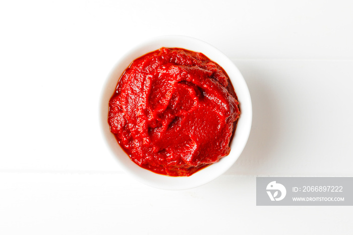 Tomato sauce in white bowl on white wooden background