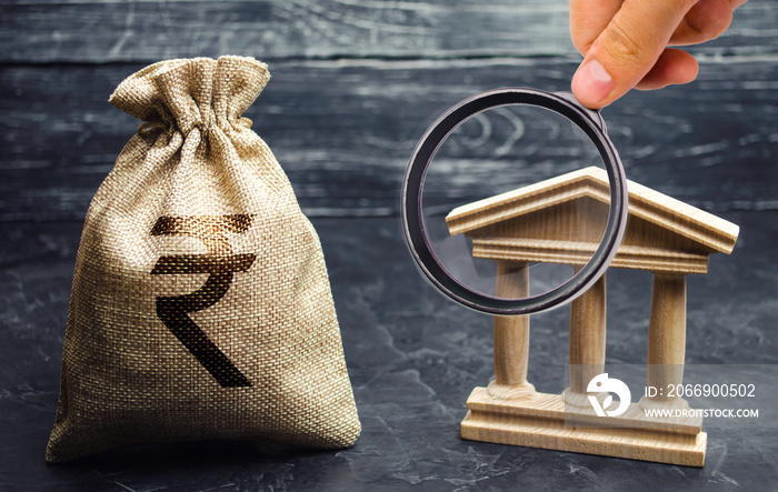 A bag with indian rupee (rupiah) and a government building. Money turnover. Deposits, investment and loan. Grants and subsidies. Payment of taxes. Credit tranches and leases. Debt repayment. Bank.