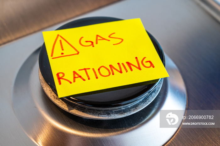 Gas stove, with yellow note next to it with the text  gas rationing . Rationing and insufficiency in gas flows. Energy crisis.