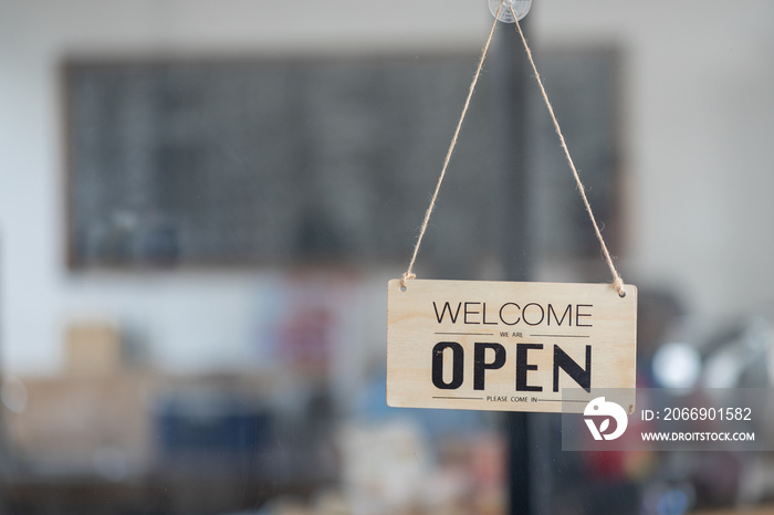 yes we’re open sign on the glass of the doors in store. welcome sign at the store