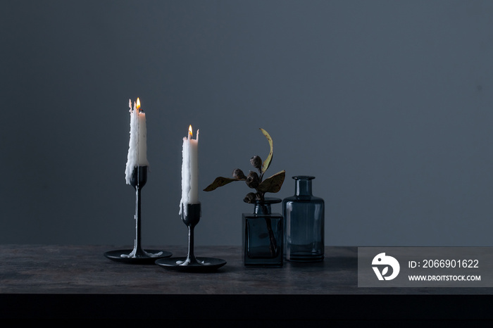 Lighted candles and vases on table.