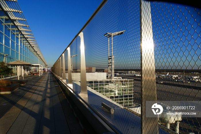 Terrace with modern architecture, security wire nets under blue sky and shadow structures on the floor.