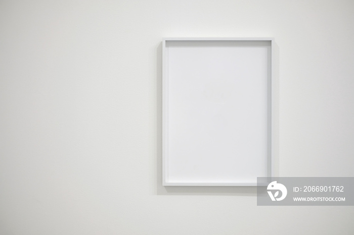 Empty white frame on white wall for interior decoration. Minimal concept