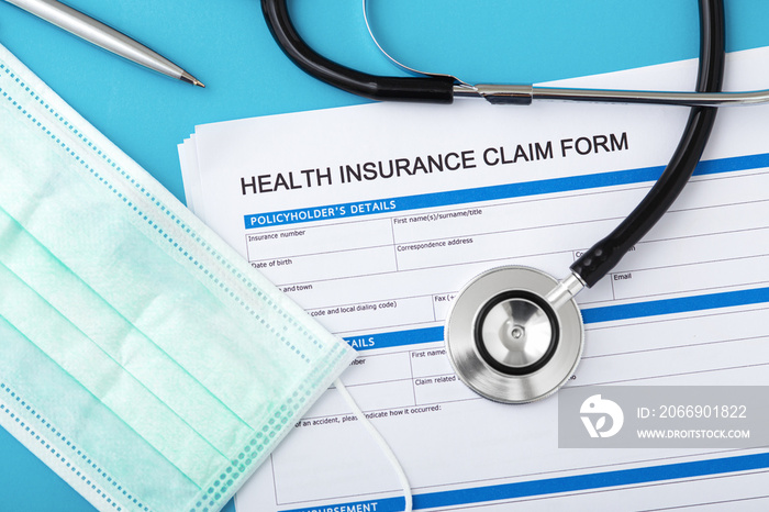 Health insurance claim form with stethoscope and surgical mask