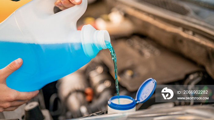 Pouring antifreeze. Filling a windshield washer tank with an antifreeze in winter cold weather.