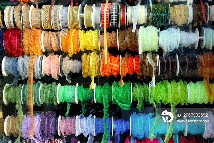 sampler of colorful rolls of threads and sewing accessories in the window of a haberdashery for fans of the sewing hobby