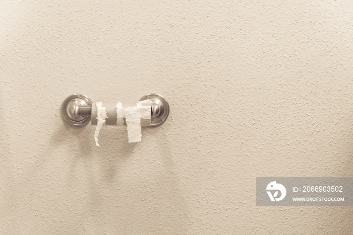 Close-up of finished toilet paper roll in bathroom. Empty roll on toilet paper holder with white wall background. Empty toilet paper roll in restroom. Out of toilet paper dilemma concept. Vintage tone