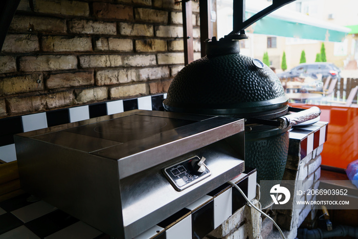 kitchen of the restaurant is equipped with an expensive ceramic grill oven and an electric stove near the window. Close-up