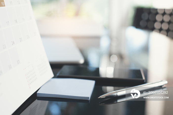 Office workplace with pen, laptop and mobile phone on glass table for business background