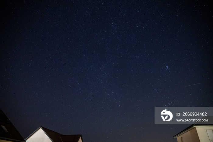 Starry sky over a housing settlement with meteorites (Perseids in August)