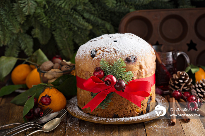 Traditional Christmas panettone with dried fruits and orange zest on rustic background