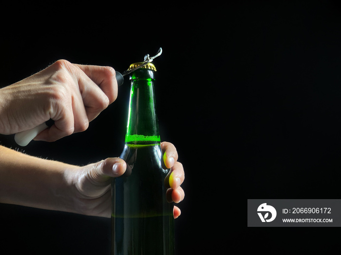 Woman’s hands is opening green bottle of beer, slow motion video