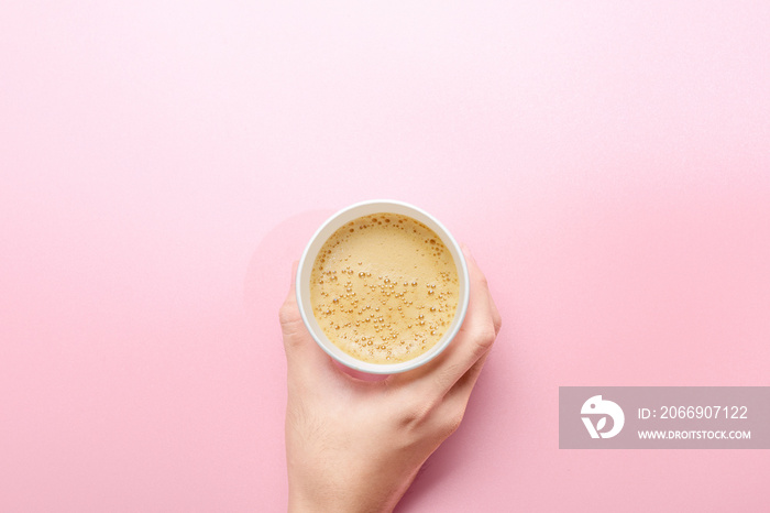 Hand holding a styrofoam cup of hot coffee