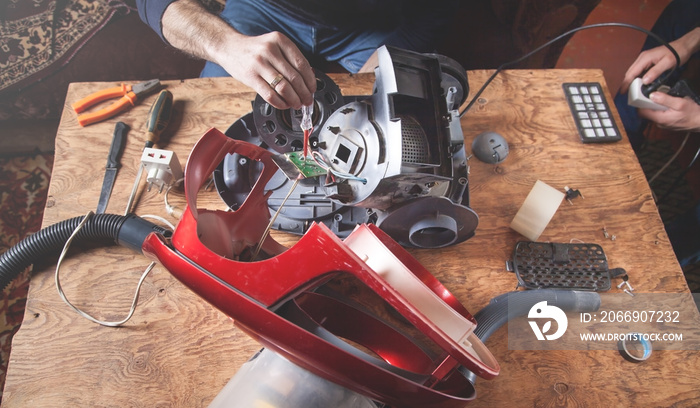 Man repairs of vacuum cleaner. Repairing