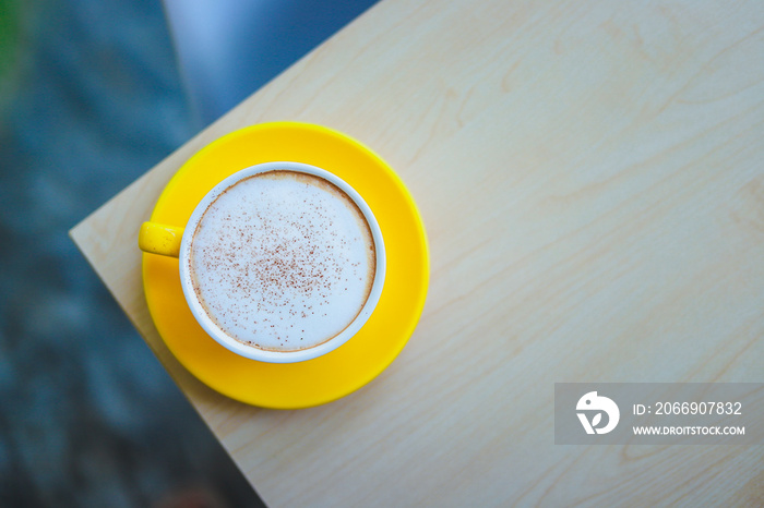 A yellow coffee mug on the table.