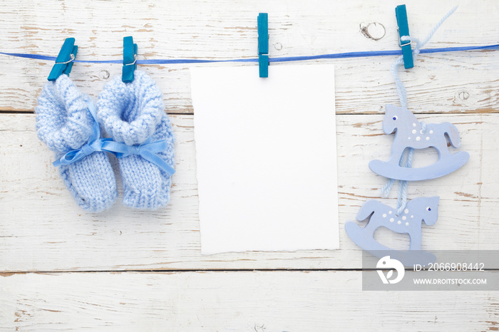 Greeting children form with blue booties and wooden horse. Flat lay